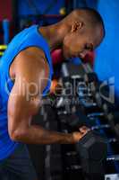 Athlete exercising with dumbbell in fitness studio