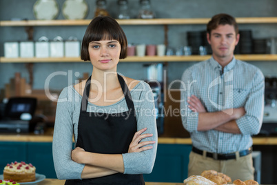 Portrait of waitress standing with arms crossed