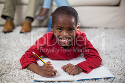 Boy doing homework while lying on the floor