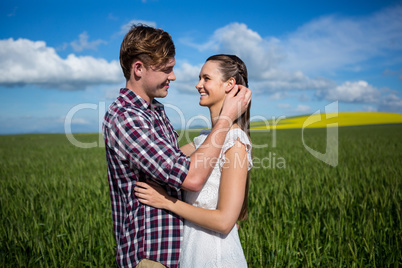 Romantic couple embracing each other in field