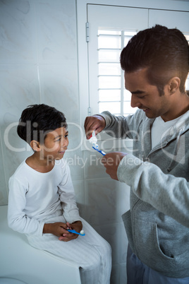 Father and son brushing teeth in the bathroom