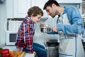 Father and son cooking food together