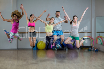 Group of fitness team jumping in fitness studio