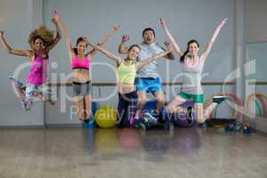 Group of fitness team jumping in fitness studio