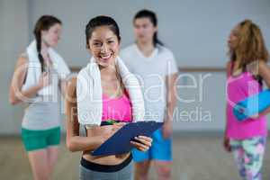 Portrait of female trainer holding clipboard