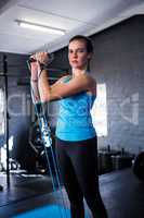Portrait of serious female athlete stretching resistance band