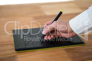 Hand of graphic designer using graphic tablet