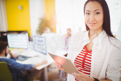 Portrait of happy businesswoman using tablet computer at creative office