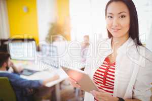 Portrait of happy businesswoman using tablet computer at creative office