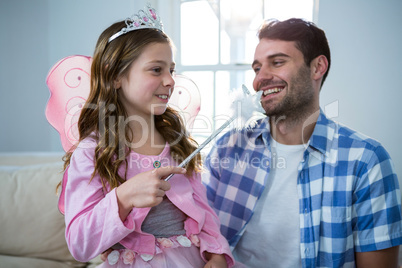 Girl dressed up in a fairy costume interacting with father