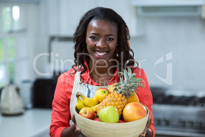 Portrait of woman holding bowl of fruits