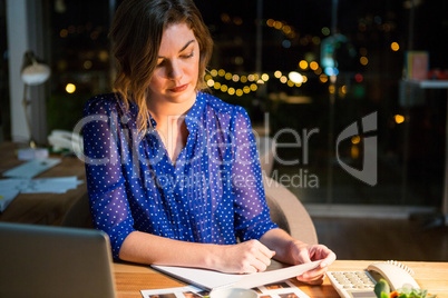 Businesswoman reading document at her desk