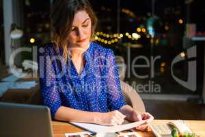 Businesswoman reading document at her desk