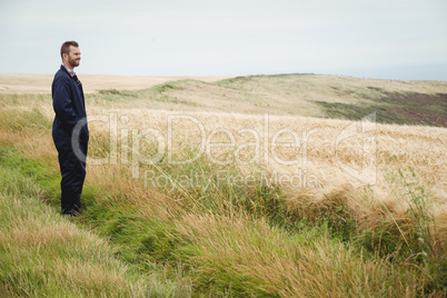 Thoughtful farmer standing in field