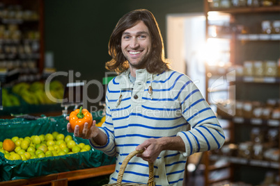 Man with a basket selecting bell pepper in organic section