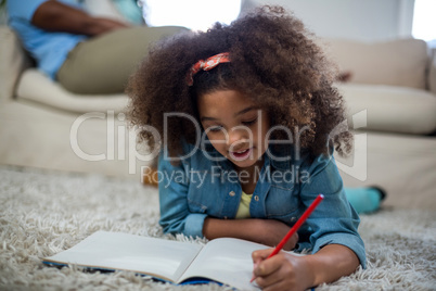 Girl doing homework while lying on the floor