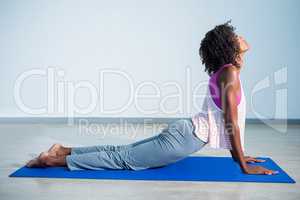 Woman doing cobra pose on exercise mat