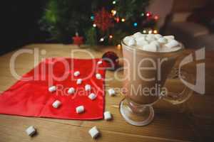 Cup of coffee with marshmallow on wooden table