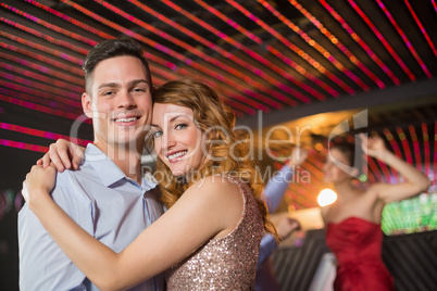 Smiling couple embracing each other in bar