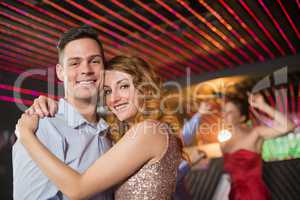 Smiling couple embracing each other in bar