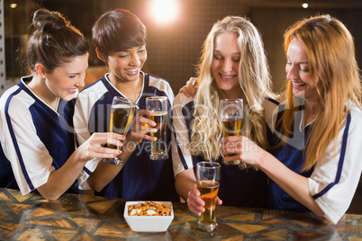 Group of friends toasting glass of beer in party