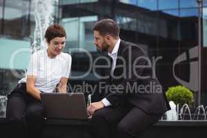 Businesspeople discussing over laptop