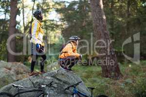 Biker couple looking at a view in forest