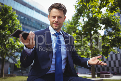 Portrait of handsome businessman holding mobile phone