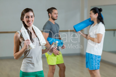 Portrait of woman holding water bottle and towel