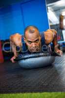Portrait of serious athlete with BOSU ball in gym