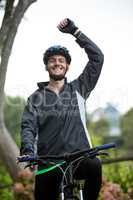 Male cyclist standing with mountain bike in park