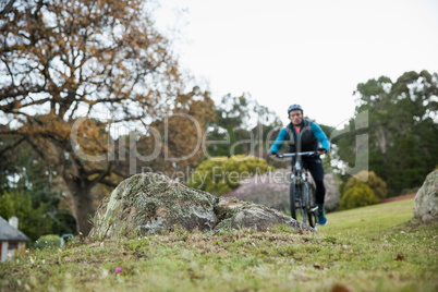 Male mountain biker riding bicycle in the forest