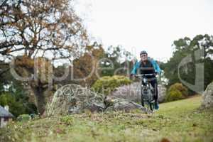 Male mountain biker riding bicycle in the forest