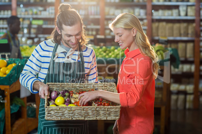 Woman selecting fresh vegetables from basket