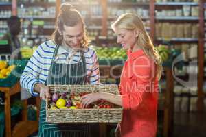 Woman selecting fresh vegetables from basket