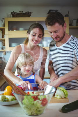 Happy family preparing salad in the kitchen