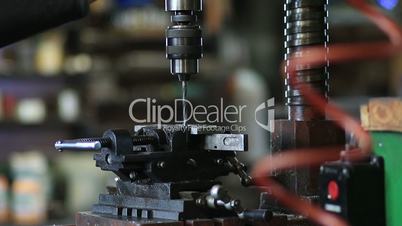 Employee drilling hole in flat steel plate