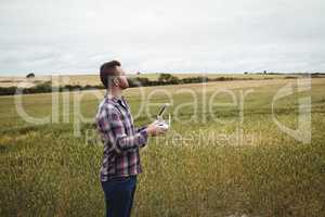 Farmer using agricultural device while examining in field