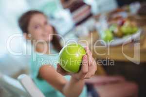 Smiling girl showing a green apple