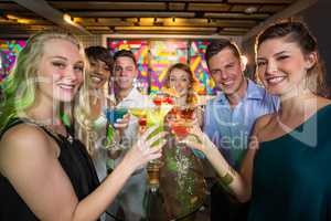 Group of friends toasting glass of cocktail in bar