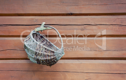 Old wicker basket hanging on wooden wall