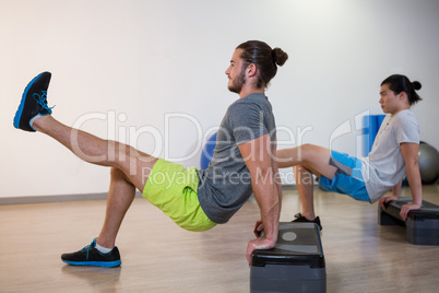 Two men doing aerobic exercise on stepper