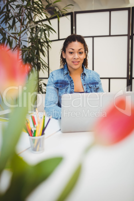 Confident graphic designer at desk with laptop