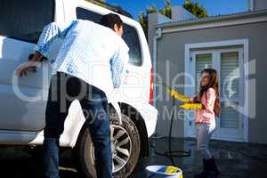 Father and daughter washing car together