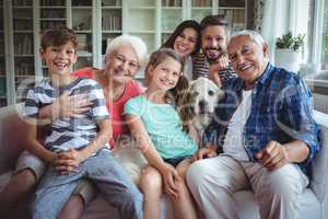 Portrait of happy multi-generation family sitting on sofa in living room