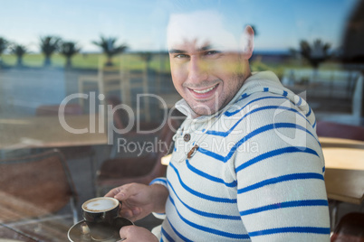Smiling man holding a coffee cup