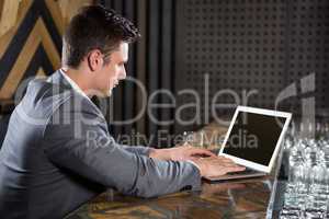 Man using laptop in bar counter