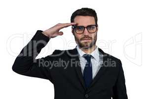 Businessman saluting against white background