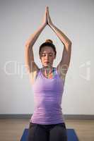 Woman sitting in lotus pose with eyes closed