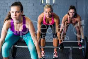 Female athletes lifting barbells